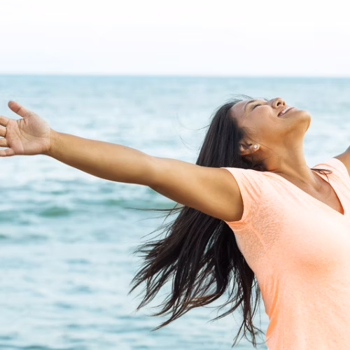 Woman with her arms stretched looking to the sky